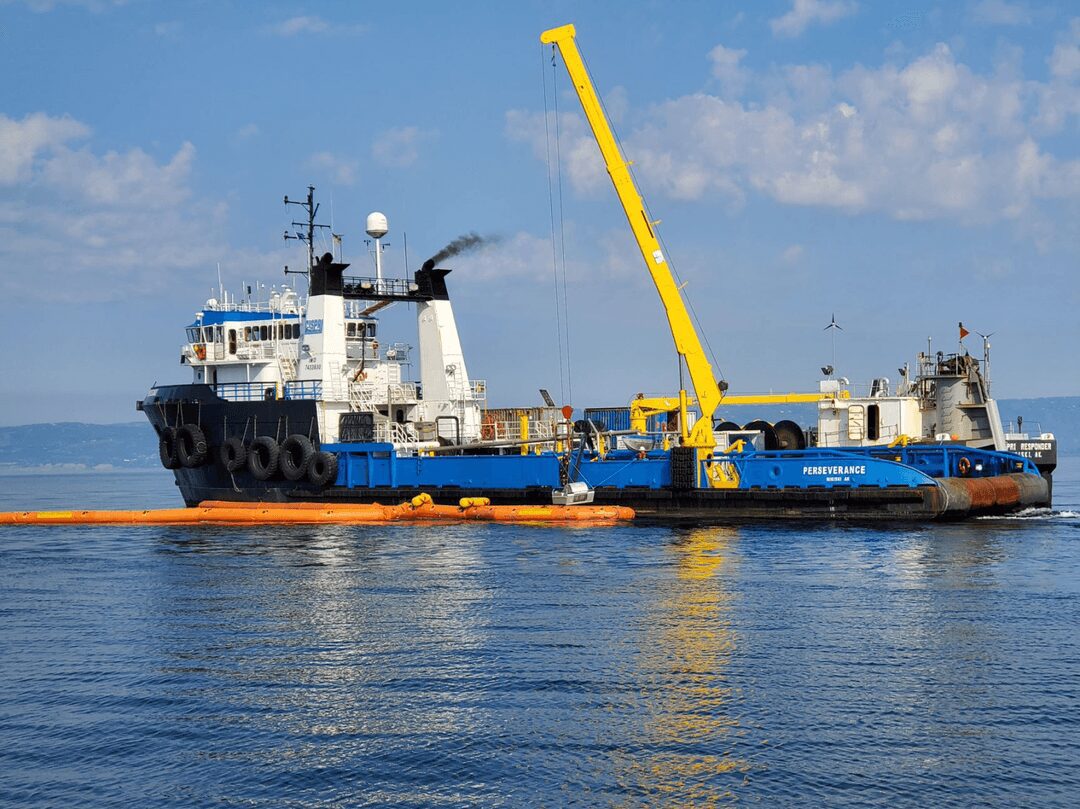 Boat working on water under blue sky