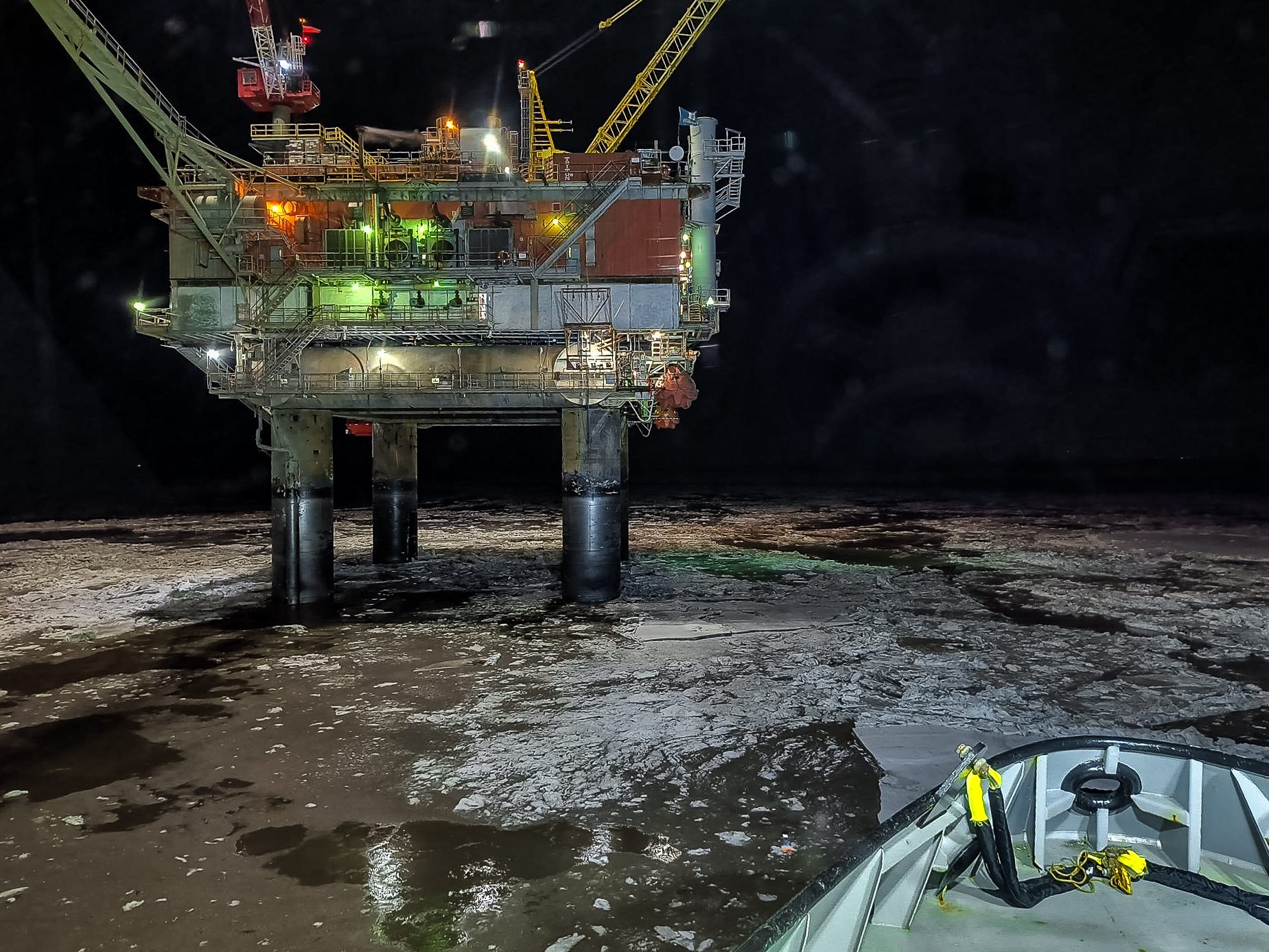 Illuminated oil rig in icy waters